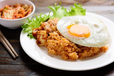 Kimchi pilavı, ahşap arka planda kızarmış yumurta, Kore yemeği.