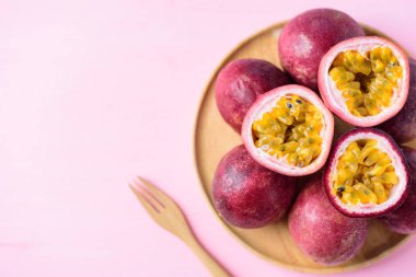 Tahta tabakta taze tutku meyvesi ve kopyalanmış pembe zemin üzerinde çatal.