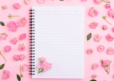 Günlük not defteri ve pembe arka planda pembe gül.