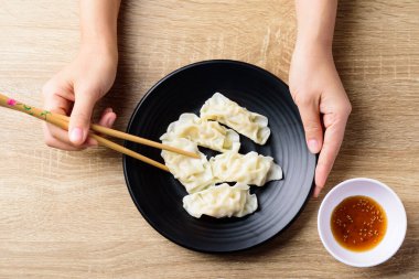 İnce dilimlenmiş domuz eti ve karidesle doldurulmuş buğulanmış wonton hamur tatlısı yemek çubukları, Asya yemekleri, üst manzara.