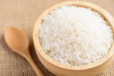 Organik Tayland Jasmine pirinç taneleri kasede ve kaşıkta pişmeye hazırlanıyor.