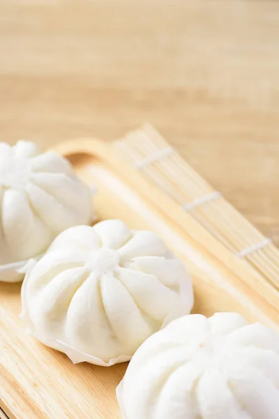 steamed buns stuffed with minced pork on wooden plate, Asian food