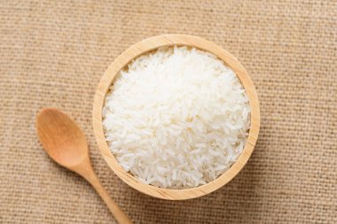 Organik Tayland yasemin pilavı ahşap kase ve kaşık içinde pişmeye hazırlanıyor.