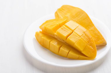 Olgun mango meyvesi beyaz tabakta dilimlenmiş, yemeye hazır, tropikal meyve, Tayland mangosu (Nam Dok Mai)