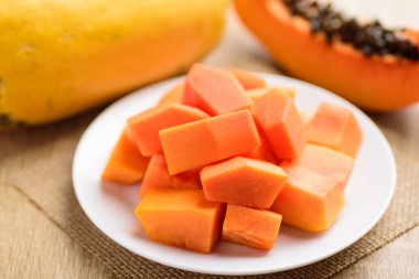 Dilimlenmiş papaya meyvesi, beyaz tabakta yemeye hazır, tropik meyve.