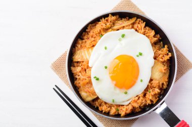 Tavada kızarmış yumurtalı kimchi pilavı ve beyaz arka planda çubuklar, Kore yemeği, Top View.