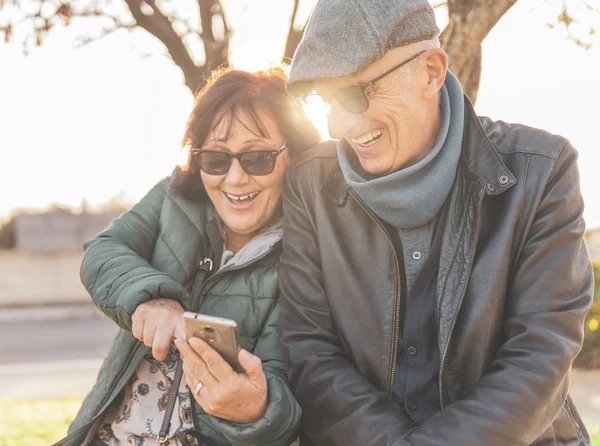 Retired couple enjoying free time taking funny selfie - middle-a