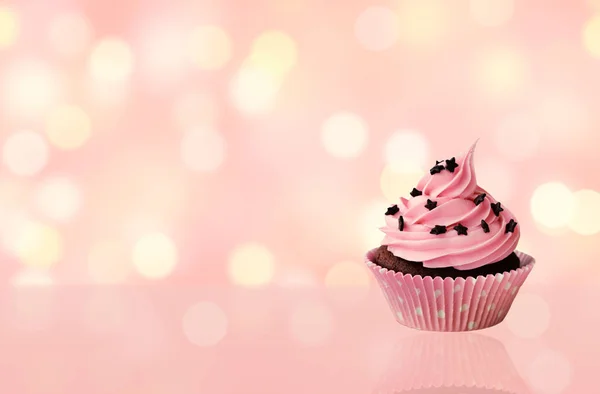 Delicioso cumpleaños cupcake rosa con luces borrosas bokeh backgr —  Fotos de Stock