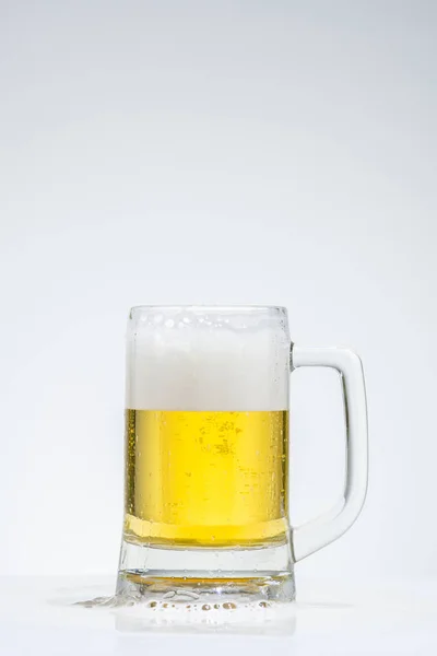 Glas bier met schuim op een grijze achtergrond — Stockfoto