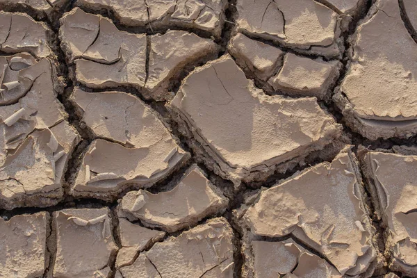 Textúra a háttér, száraz talajviszonyok repedések, miután a víz kiszárad. — Stock Fotó