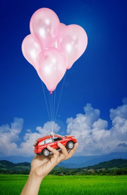 birçok balon üzerinde mavi gökyüzü uçan asılı el kadın kırmızı arabaya. Otomobil kıymet kavramı
