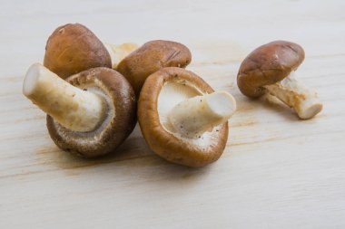 Ham shiitake mantar ahşap arka plan üzerinde kapatın.