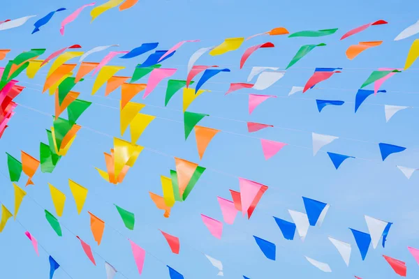 multi colored party rainbow flags on blue sky for celebration