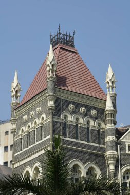 Mimarisi: kemerli pencereler, çatı kiremitleri ve taş duvar yakınındaki Mumbai, Hindistan ile binanın kapat