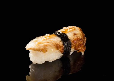 Siyah arka planda ton balıklı suşi.