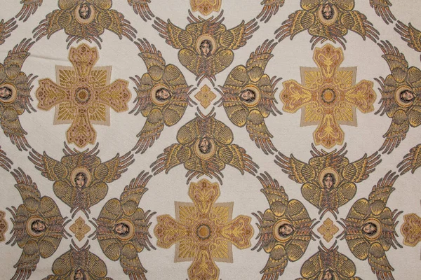 Sarı ipek kumaş, altın haçlar ve melekler.