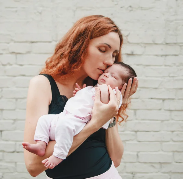 A fiatal csinos nők az csók újszülött Baby.Touching pillanat, szerelem — Stock Fotó