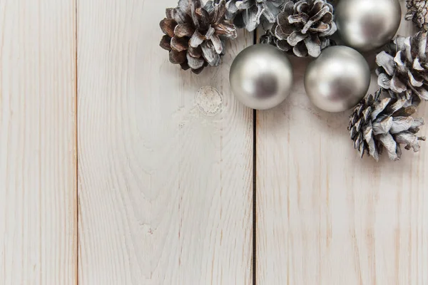 銀のボールと木製のテーブルの上の白い冬コーン。クリスマス背景 — ストック写真