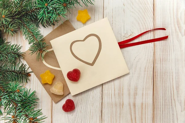 Albero di Natale ramo, giuggiola e cartoline con cuori.Tavolo in legno bianco — Foto Stock