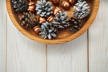 Noel kompozisyon. Beyaz koniler ve altın meşe palamudu. Ahşap beyaz masa.