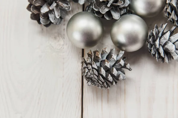 銀のボールと木製のテーブルの上の白い冬コーン。クリスマスの組成 — ストック写真