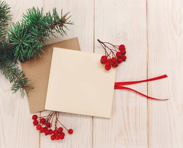 Noel mokup. Ağaç dalı çerçeve, boş kartları ile rowanberry. Beyaz ahşap masa.
