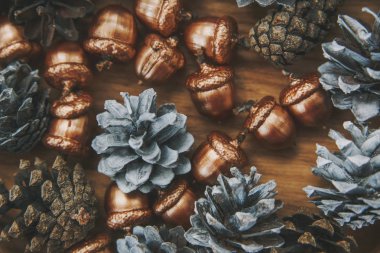 Noel arka plan. Beyaz koniler ve altın meşe palamudu. Ahşap masa.