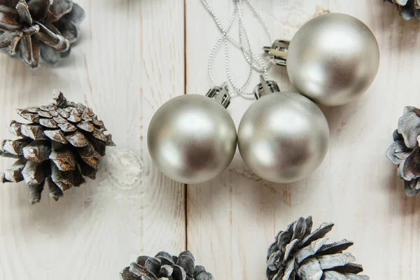 銀のボールと木製のテーブルの上の白い冬コーン。クリスマスの装飾 — ストック写真
