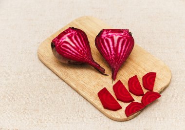 Kırmızı taze pancar, kaba masa örtüsü üzerinde parçalar kesin. Sebze