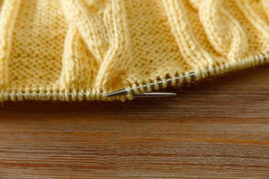 Sarı mamul, gri Needles.Hand yapılan örgü örme; Fancywork.Wooden arka plan