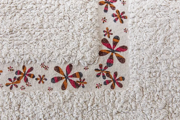 Witte tapijt van de ruwe textuur met kleurrijke bloem — Stockfoto