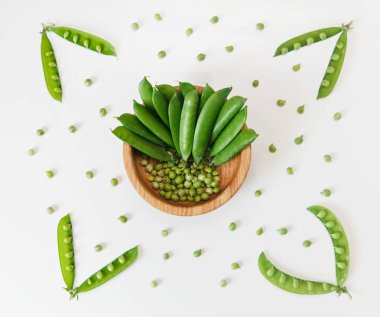 Arka plan yeşil taze bezelye ve izole center.white ahşap plaka bezelye. Üstten Görünüm.