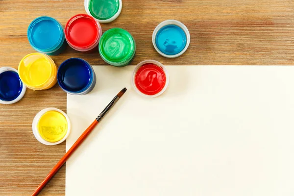 Lattine colorate con vernice, pennello e carta.tavolo in legno.copyspace — Foto Stock