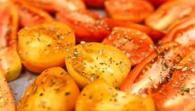 Sarı ve kırmızı domates bitki baharatlar ile kesti. Gıda arka plan.