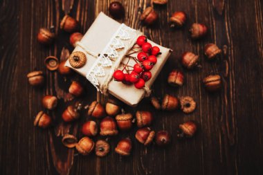 Hediye kutusu Kraft kağıt ahşap arka plan üzerinde sonbahar dekorasyonu ile. Sonbahar kutlama. El tarzı yaptı. Üstten Görünüm