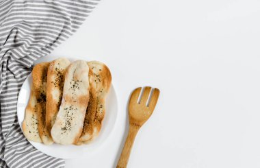 Baharatlı ince İtalyan ekmeği. İnce tortilla. Tabakta geleneksel İtalyan Focaccia. Beyaz arka plan.