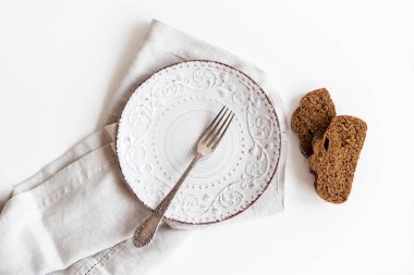 Boş tabakla servis edilen masa, tahtada halk ve ekmek. Yemeye hazır. Beyaz arka plan.