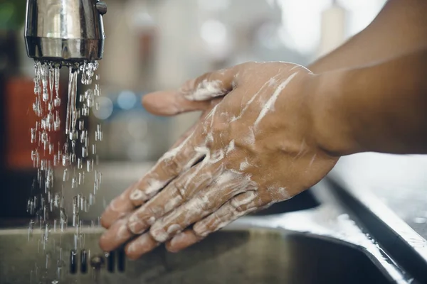 Always start with clean hands to prevent spreading of the coronavirus (Covid-19). Cropped shot of an asian man washing his hands at home