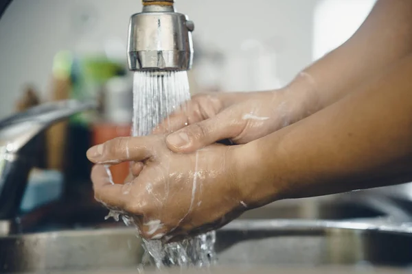 Always start with clean hands to prevent spreading of the coronavirus (Covid-19). Cropped shot of an asian man washing his hands at home