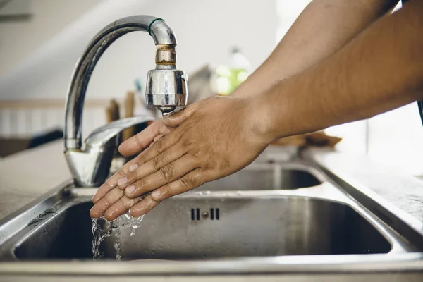 Always start with clean hands to prevent spreading of the coronavirus (Covid-19). Cropped shot of an asian man washing his hands at home