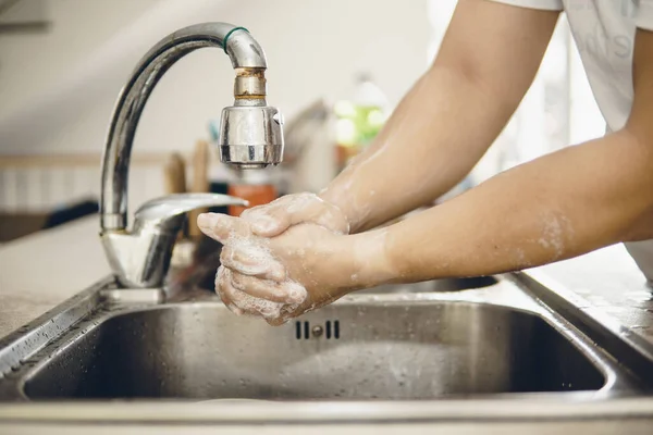 Always start with clean hands to prevent spreading of the coronavirus (Covid-19). Cropped shot of an asian man washing his hands at home