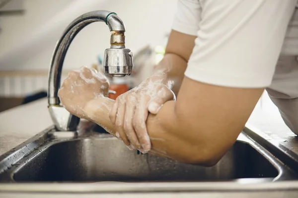 Always start with clean hands to prevent spreading of the coronavirus (Covid-19). Cropped shot of an asian man washing his hands at home