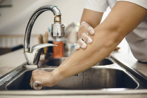 Always start with clean hands to prevent spreading of the coronavirus (Covid-19). Cropped shot of an asian man washing his hands at home