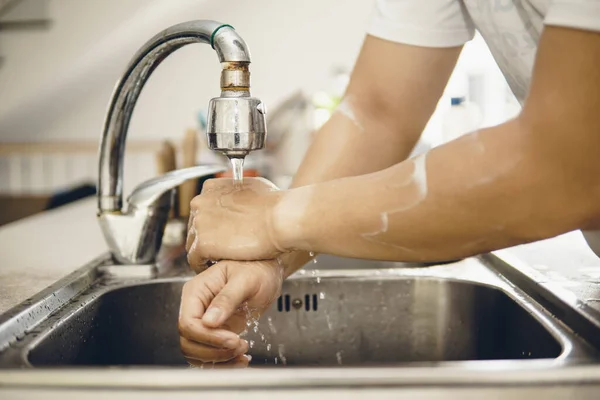 Always start with clean hands to prevent spreading of the coronavirus (Covid-19). Cropped shot of an asian man washing his hands at home