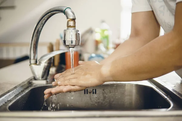 Always start with clean hands to prevent spreading of the coronavirus (Covid-19). Cropped shot of an asian man washing his hands at home