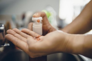 Koronavirüsün yayılmasını önlemek için virüsten, bakterilerden ve iyi hijyenden ellerini yıkamak / temizlemek için algohol jeli pompalamak veya elle itmek (Covid-19)