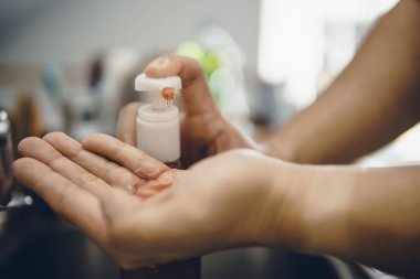 Koronavirüsün yayılmasını önlemek için virüsten, bakterilerden ve iyi hijyenden ellerini yıkamak / temizlemek için algohol jeli pompalamak veya elle itmek (Covid-19)