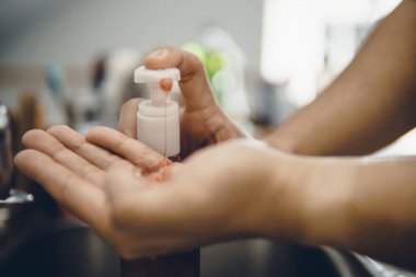 Koronavirüsün yayılmasını önlemek için virüsten, bakterilerden ve iyi hijyenden ellerini yıkamak / temizlemek için algohol jeli pompalamak veya elle itmek (Covid-19)