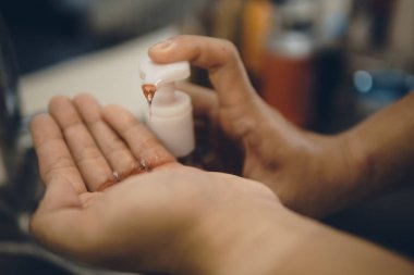 Koronavirüsün yayılmasını önlemek için virüsten, bakterilerden ve iyi hijyenden ellerini yıkamak / temizlemek için algohol jeli pompalamak veya elle itmek (Covid-19)