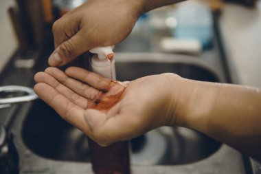 Koronavirüsün yayılmasını önlemek için virüsten, bakterilerden ve iyi hijyenden ellerini yıkamak / temizlemek için algohol jeli pompalamak veya elle itmek (Covid-19)